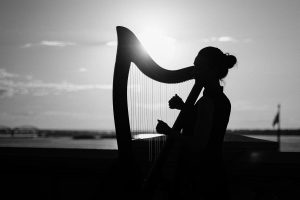 Black and white picture of a woman playing a harp 